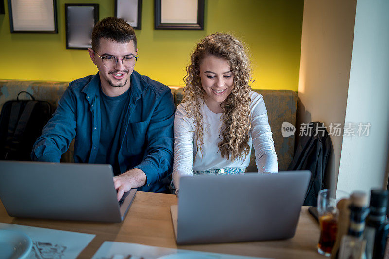 Business people working together at a café using their laptops